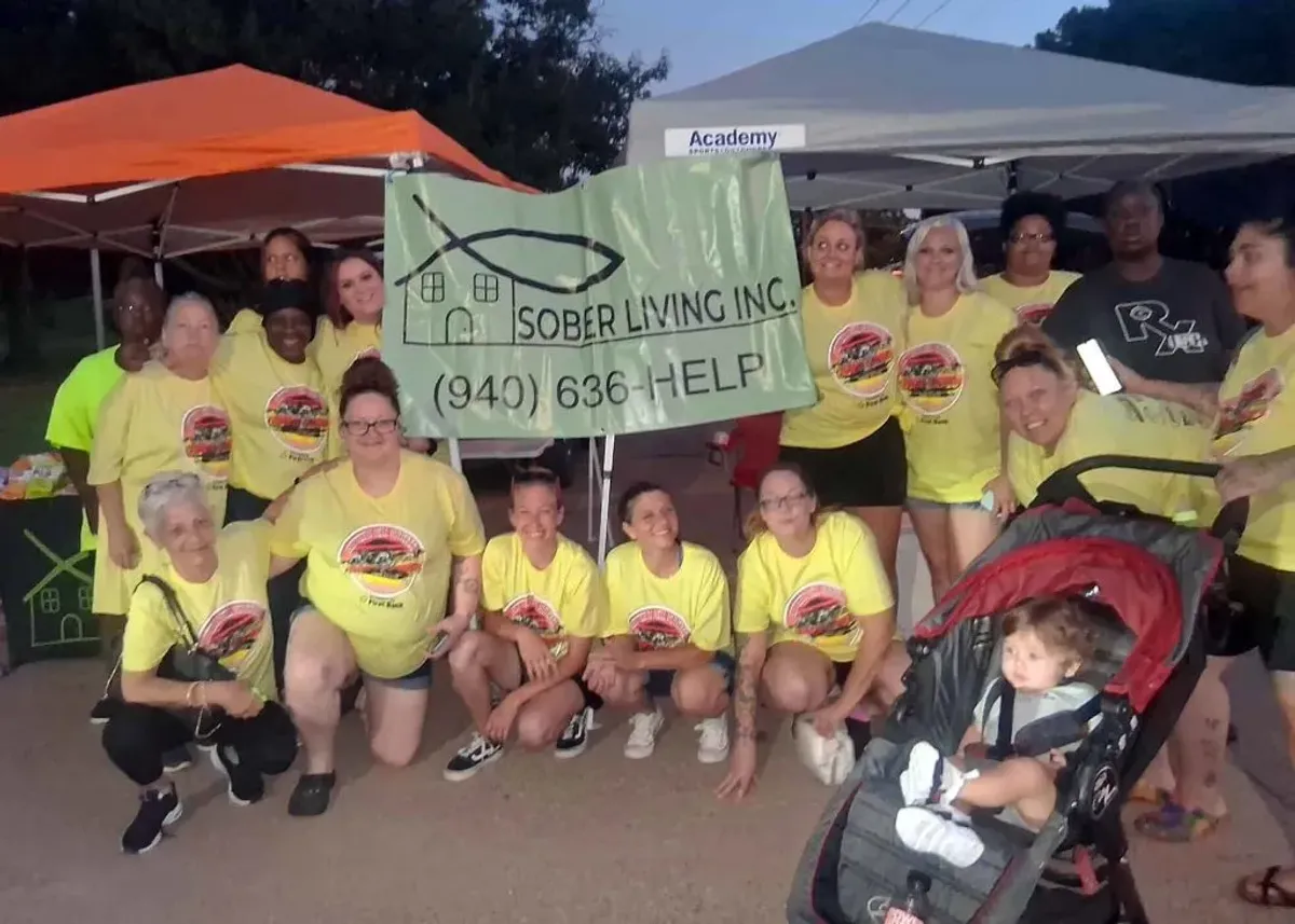 Sober Living, Inc. community members gathered beneath event tents with the organization banner
